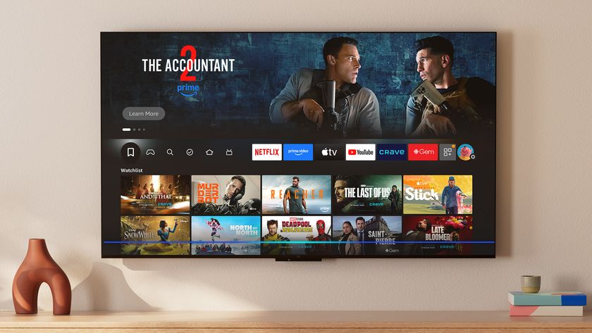 The Amazon Fire TV Omni QLED (2025 edition) displaying the Fire TV smart platform home screen in a living room setting