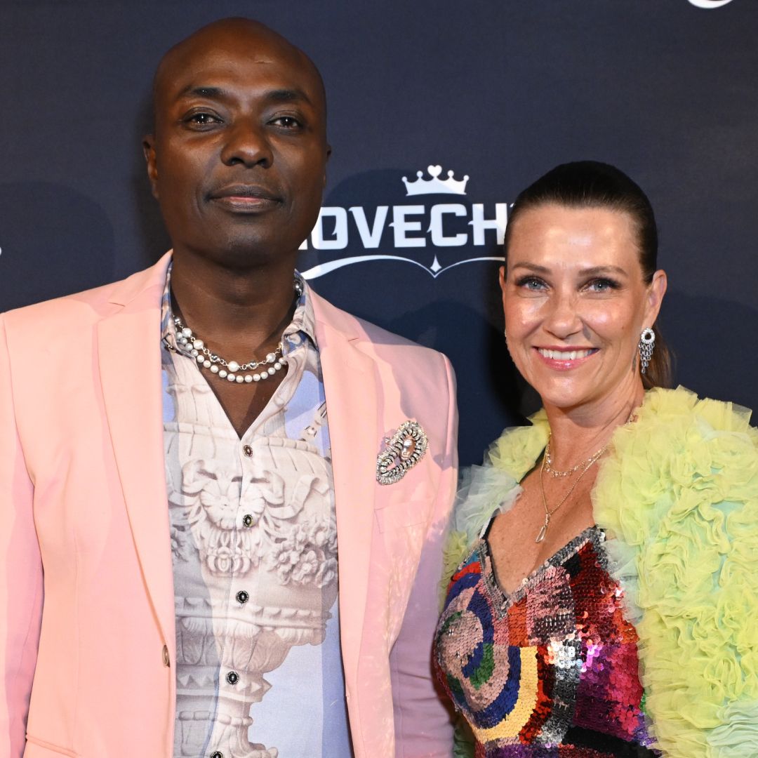 Durek Verrett wearing a pink blazer standing next to Princess Martha Louise in a sequined dress and lime jacket on a red carpet