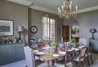 grey dining room with chandelier and colored cabinets