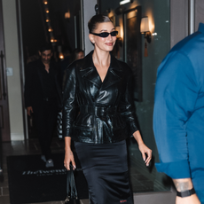 Hailey Bieber in a black leather blazer and silk black pencil skirt