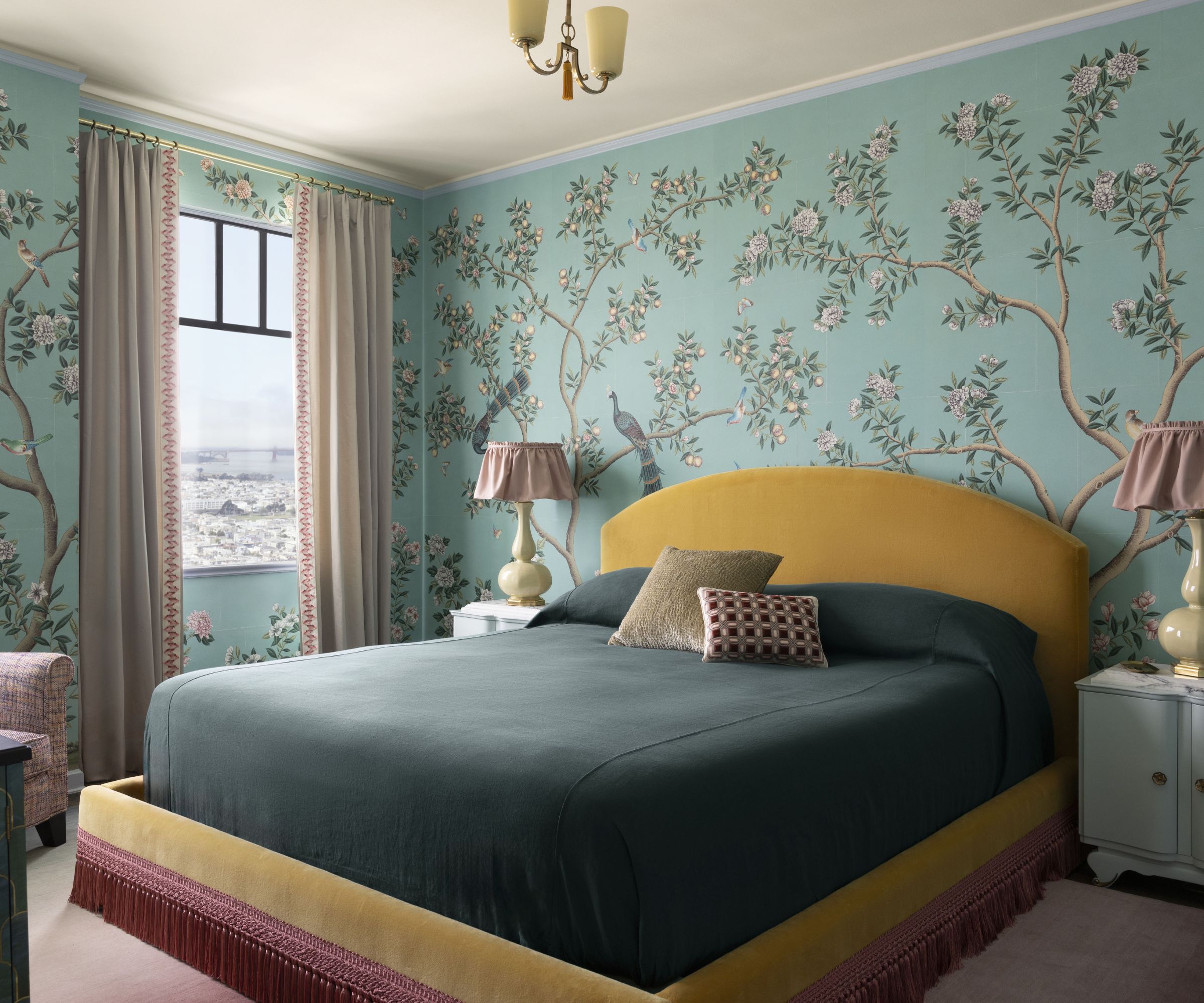 Bedroom with blue floral wallpaper, a yellow velvet upholstered bed frame and dark green sheets