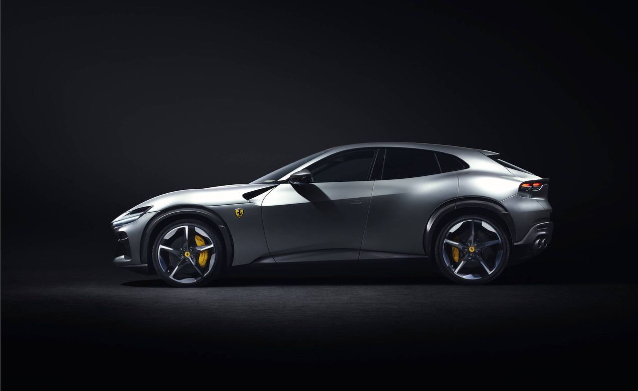 Side view of a metallic grey Ferrari Purosangue, black background