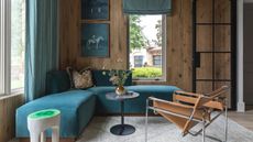 Wooden clad living room with blue velvet corner sofa