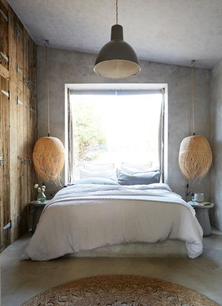 small bedroom with built in wooden wardrobe and hanging seagrass pendant lights