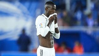 Vinicius Jr looks unhappy as he holds his shirt to his face