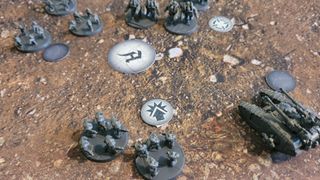 Units from Legions Imperialis face off against each other on a battlefield strewn with tokens