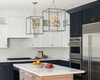 Kitchen island with caged black and gold lighting designs suspended above