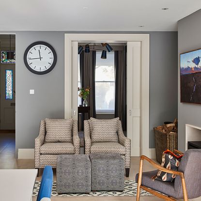 living room with grey and white wall and sofa set with floor mat