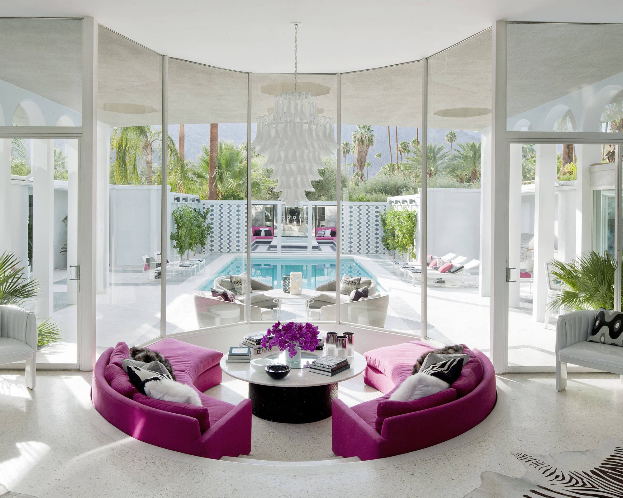 large white living room with sunken seating featuring a curved pink sofa