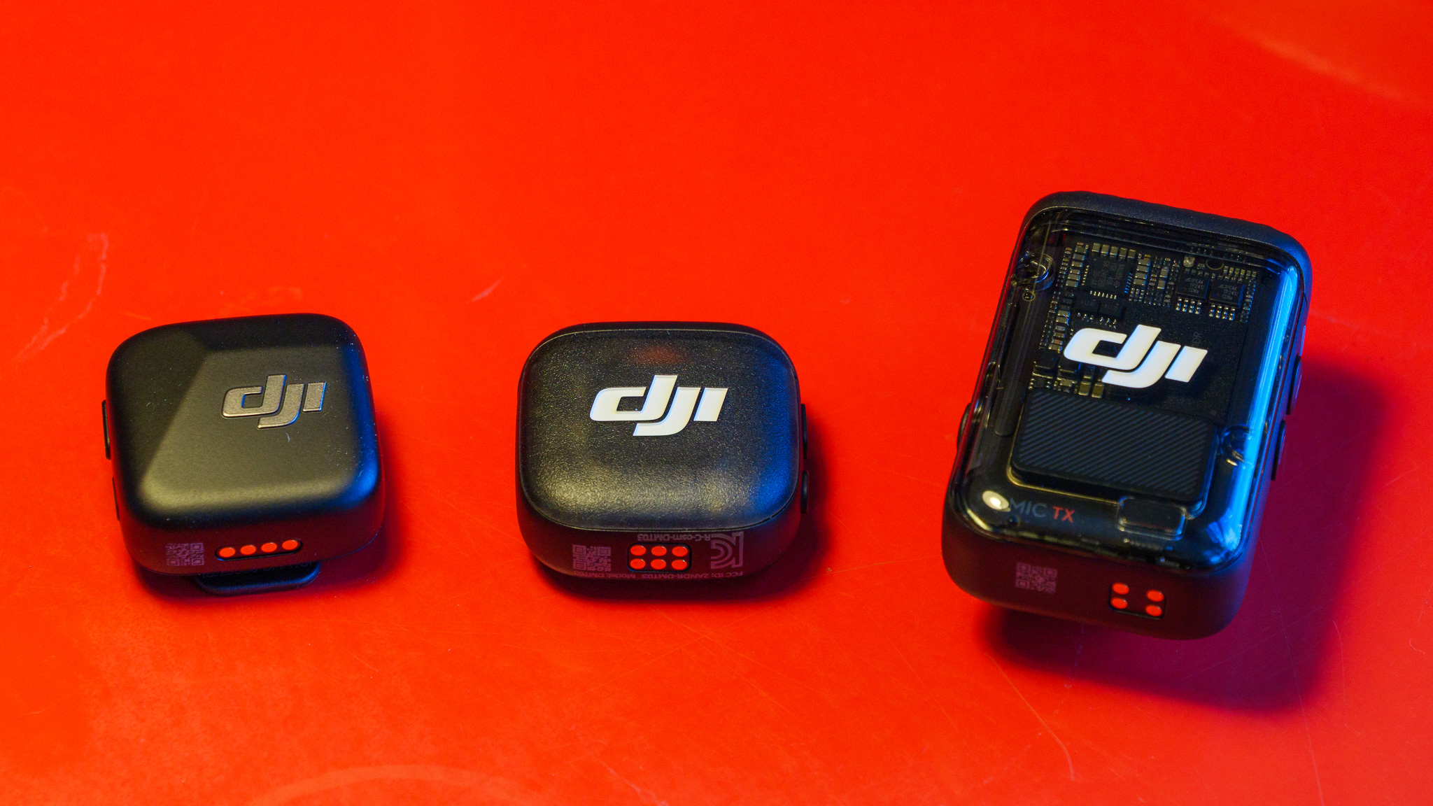 DJI Mic 3 alongside DJI Mic Mini and DJI Mic 2 wireless microphones on a red background