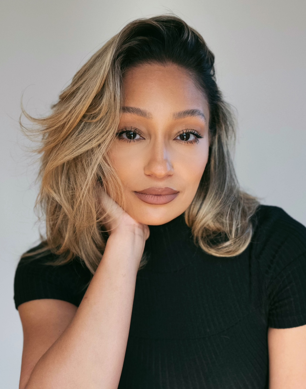 a woman with blonde medium length hair in a black short sleeve top
