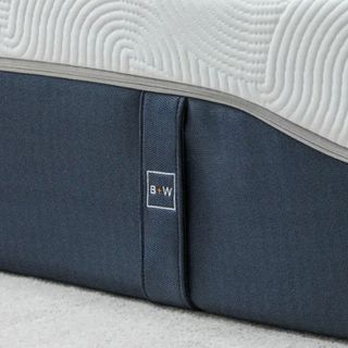 A close up of the navy side handle and quilted upper of the Brook + Wilde Ultima mattress