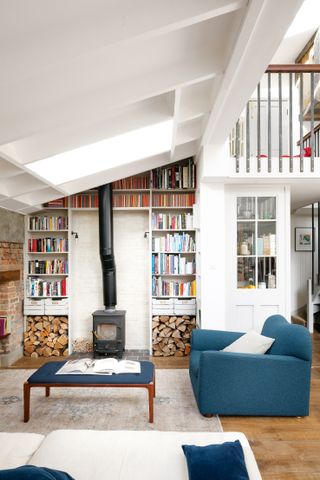 Wood burner in white living room with built in books shelves