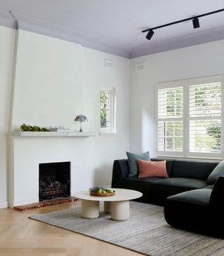 Living room with white walls, lavender ceiling and black sofa