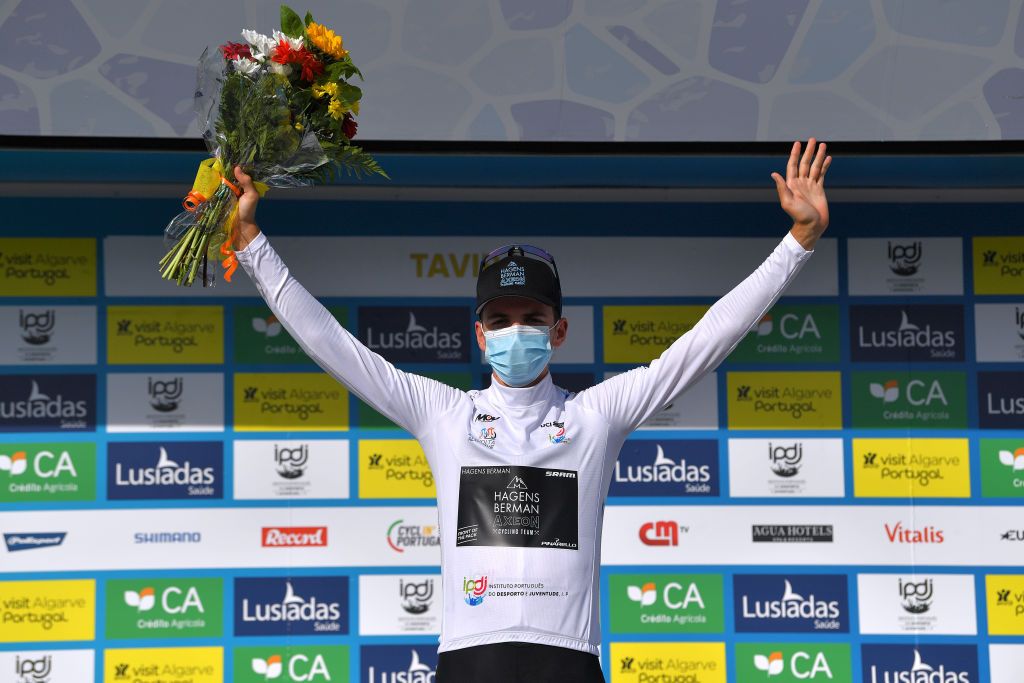 TAVIRA PORTUGAL MAY 07 Sean Quinn of United States and Team Hagens BermanAxeon White Best Young Rider Jersey celebrates at podium during the 47th Volta Ao Algarve 2021 Stage 3 a 2031km stage from Faro to Tavira Mask Covid Safety Measures Flowers VoltAlgarve VAlgarve2021 on May 07 2021 in Tavira Portugal Photo by Luc ClaessenGetty Images