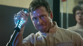 A still from the trailer for The Running Man showing Glen Powell grabbing a taser stick
