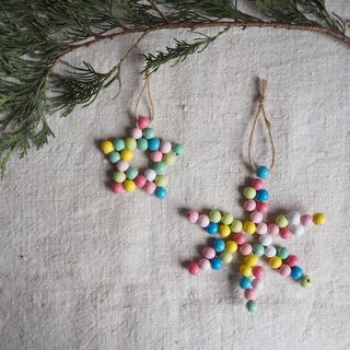 Colorful bead decorations staged on grey cloth with sprigs of fir tree