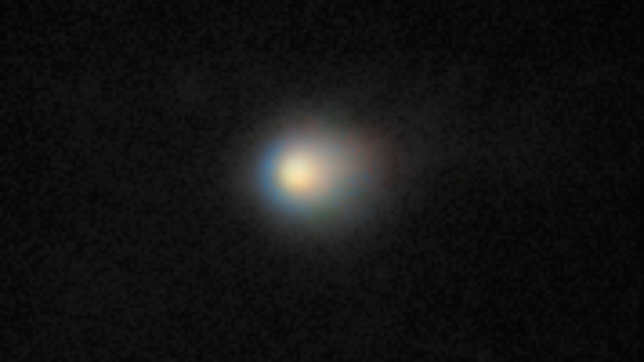 A bright dot of a comet bursts across the darkness of outer space