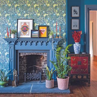 Living room with blue wallpapered chimney breast, blue walls and a blue fireplace.