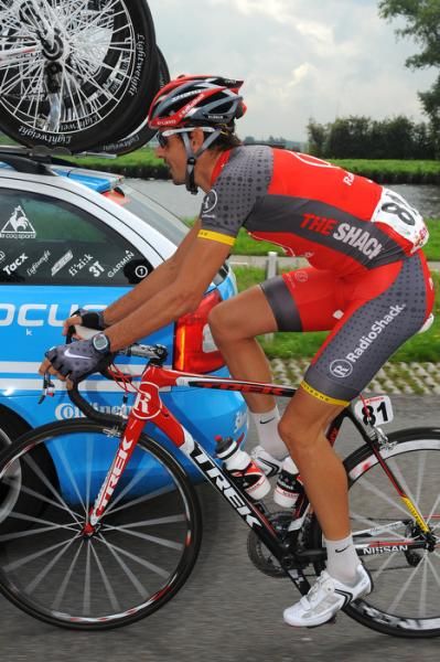 Andreas Kloeden (Radioshack) works his way through the team cars.