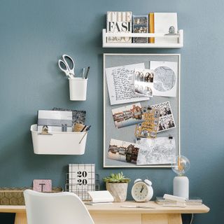 Blue home office with open wall shelving and pinboard