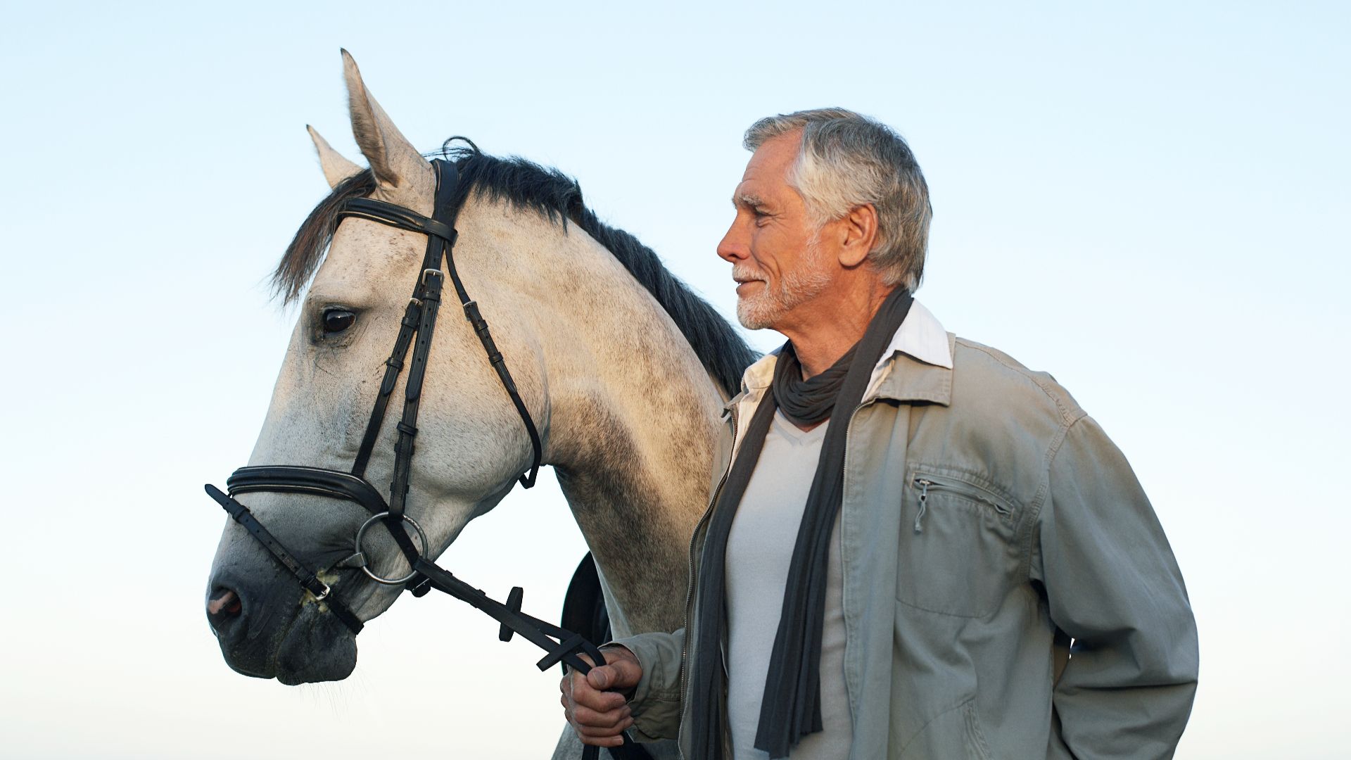 man stood with gray horse