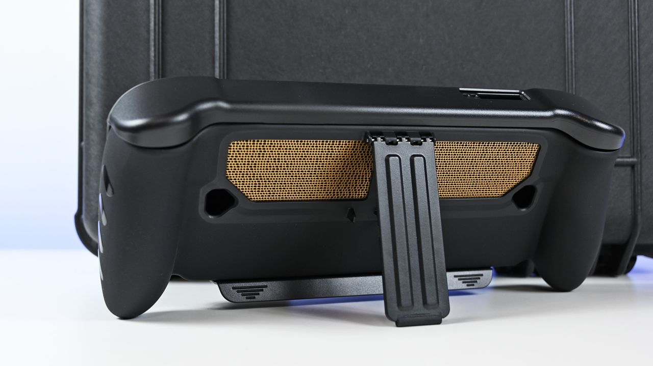 Rear view of the ROG Ally X20 in a black dbrand Killswitch case, showing the deployed kickstand and gold mesh vent skin.