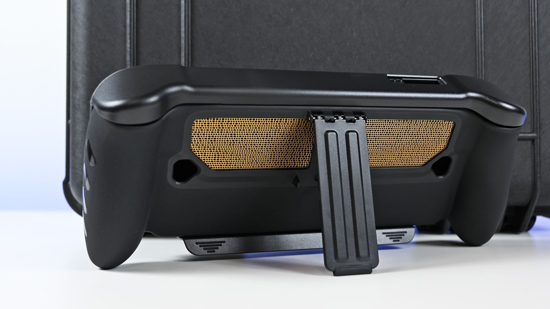Rear view of the ROG Ally X20 in a black dbrand Killswitch case, showing the deployed kickstand and gold mesh vent skin.