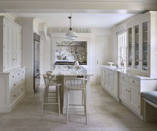 White kitchen with pendant lights over island and tall cabinets