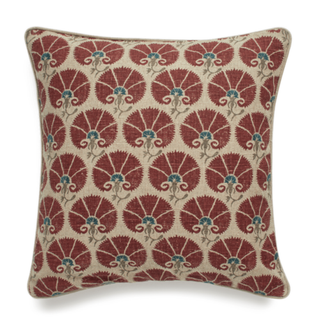A throw pillow with embroidered red designs