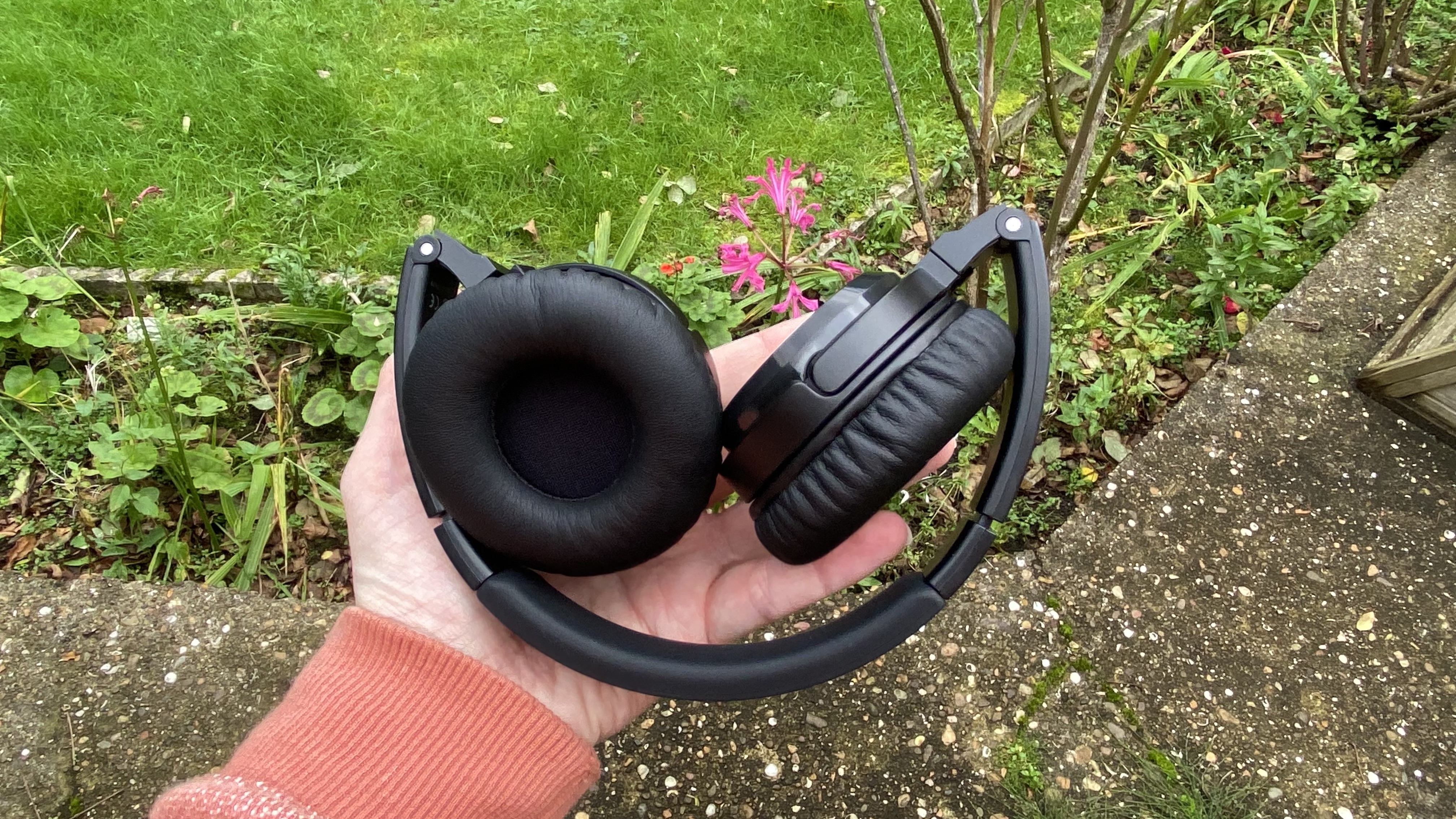 the soundmagic pt23bt headphones being folded up