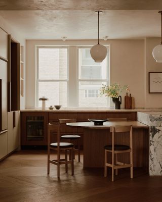 Dark wood kitchen with white marble island joined to curved wood seating area