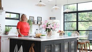 woman in a red dress standing behind a kitchen island in a modern extension