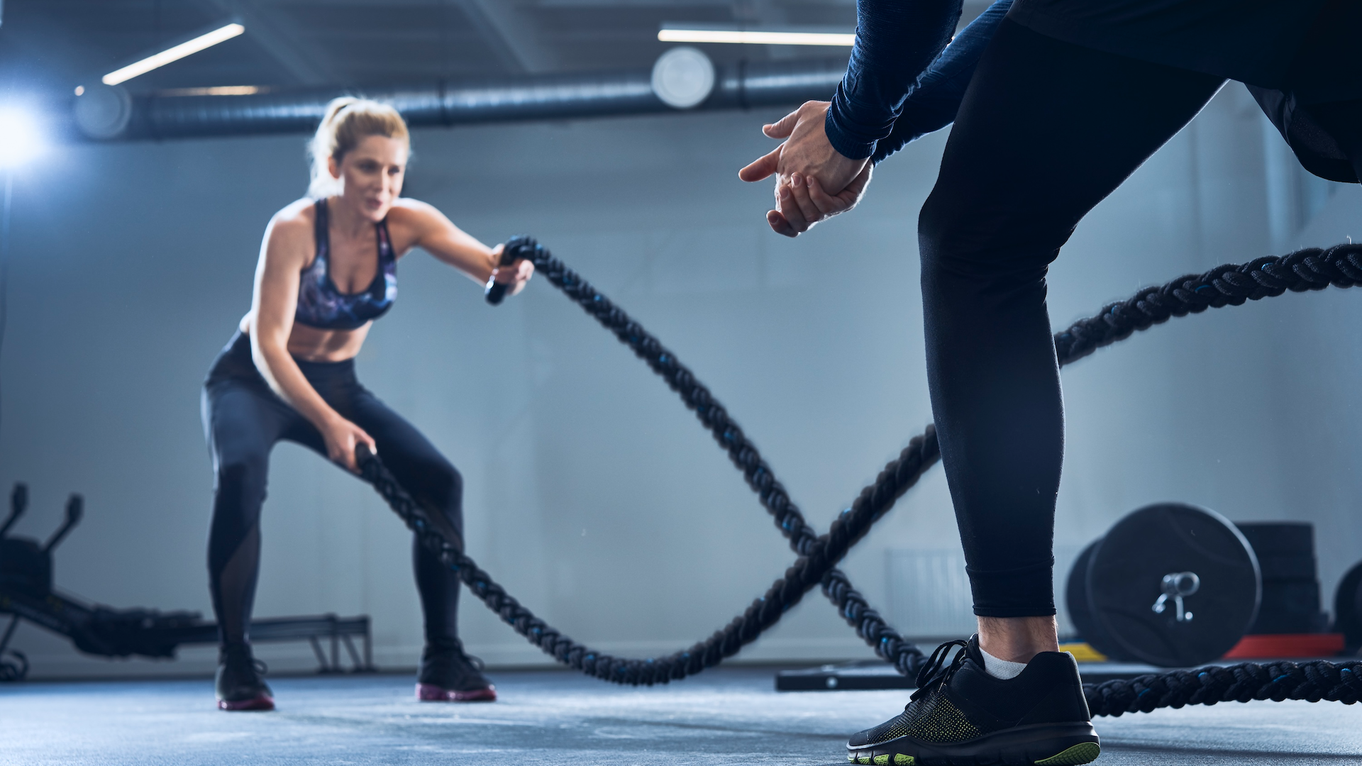 Woman using battle ropes at the gym in a personal training session