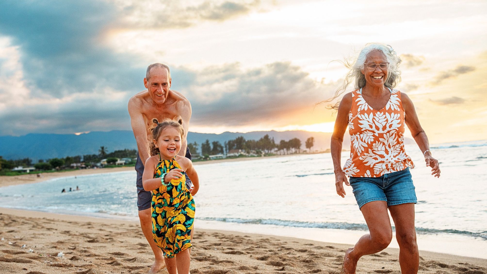 Grandparents having fun with their grand daughter on the beach.