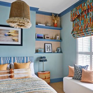 blue bedroom with patterned blinds and bedspread