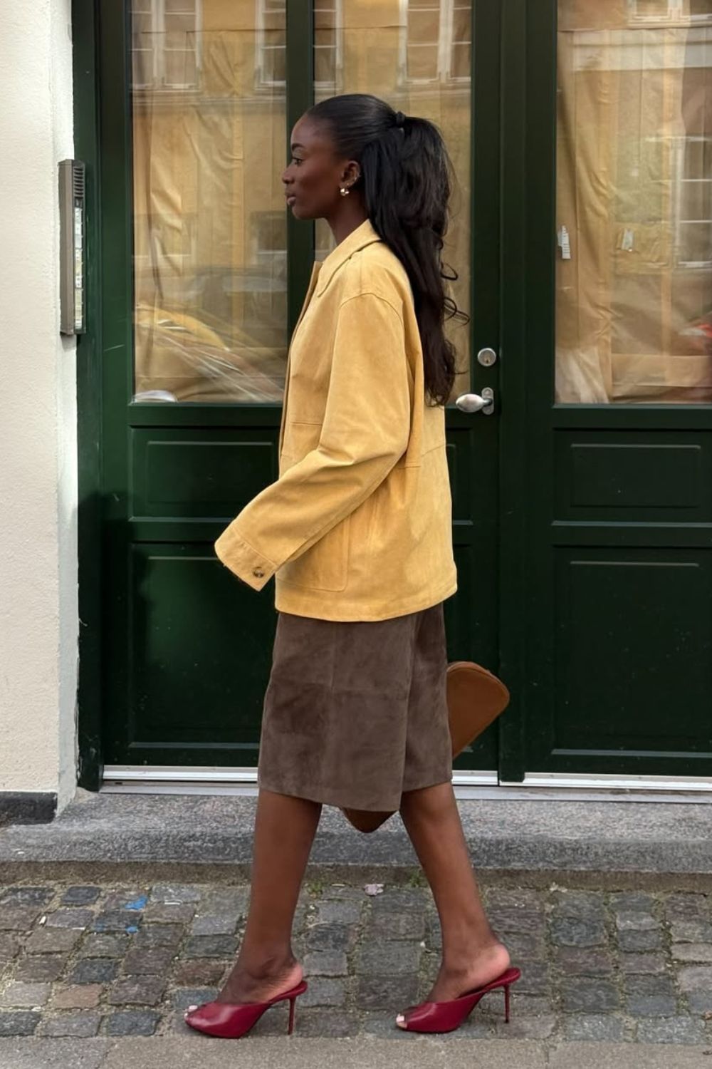 Anti-flat shoes trends winter 2025 @_livmadeline wearing a yellow suede jacket, suede shorts and red peeptoe mules