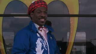Eddie Murphy in blue coveralls, covered in pink milkshake in Coming to America