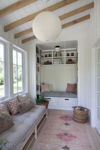 screened in porch with white wood walls and built in seating