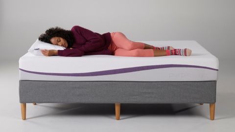 Purple Original mattress review lead image shows a woman lying on her side on said mattress