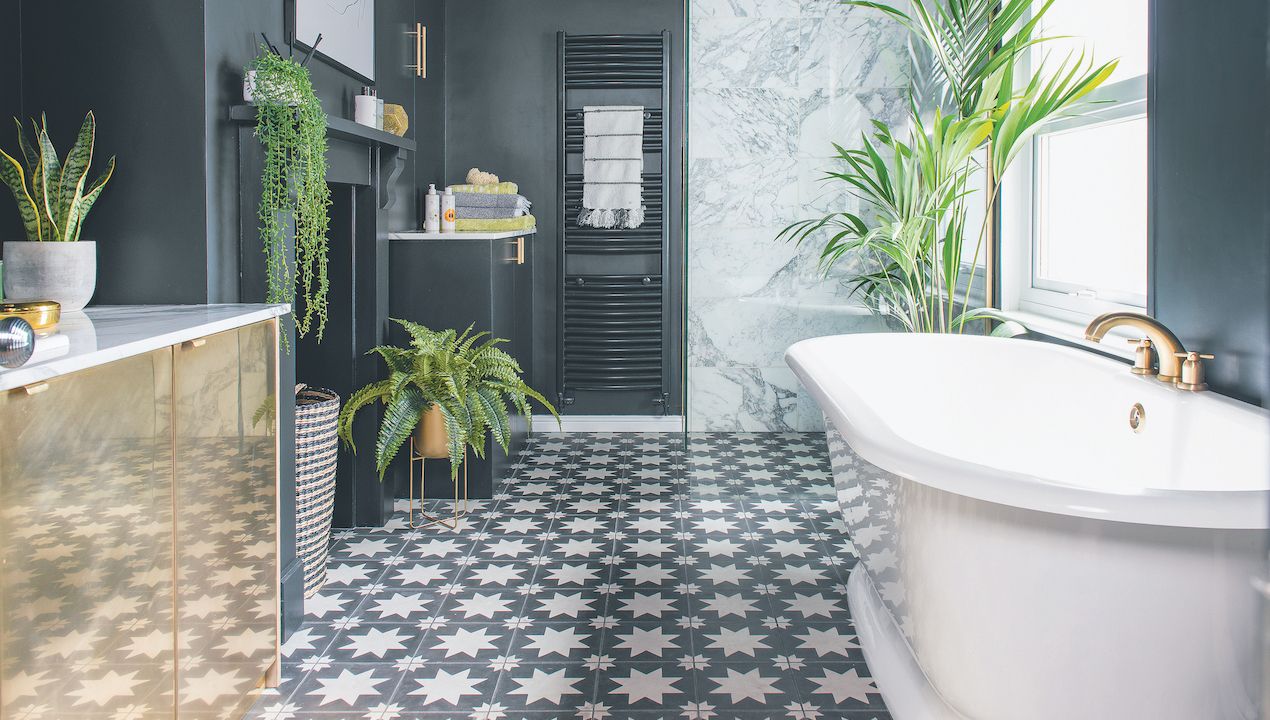 black bathroom with star tiles, white bath and gold vanity