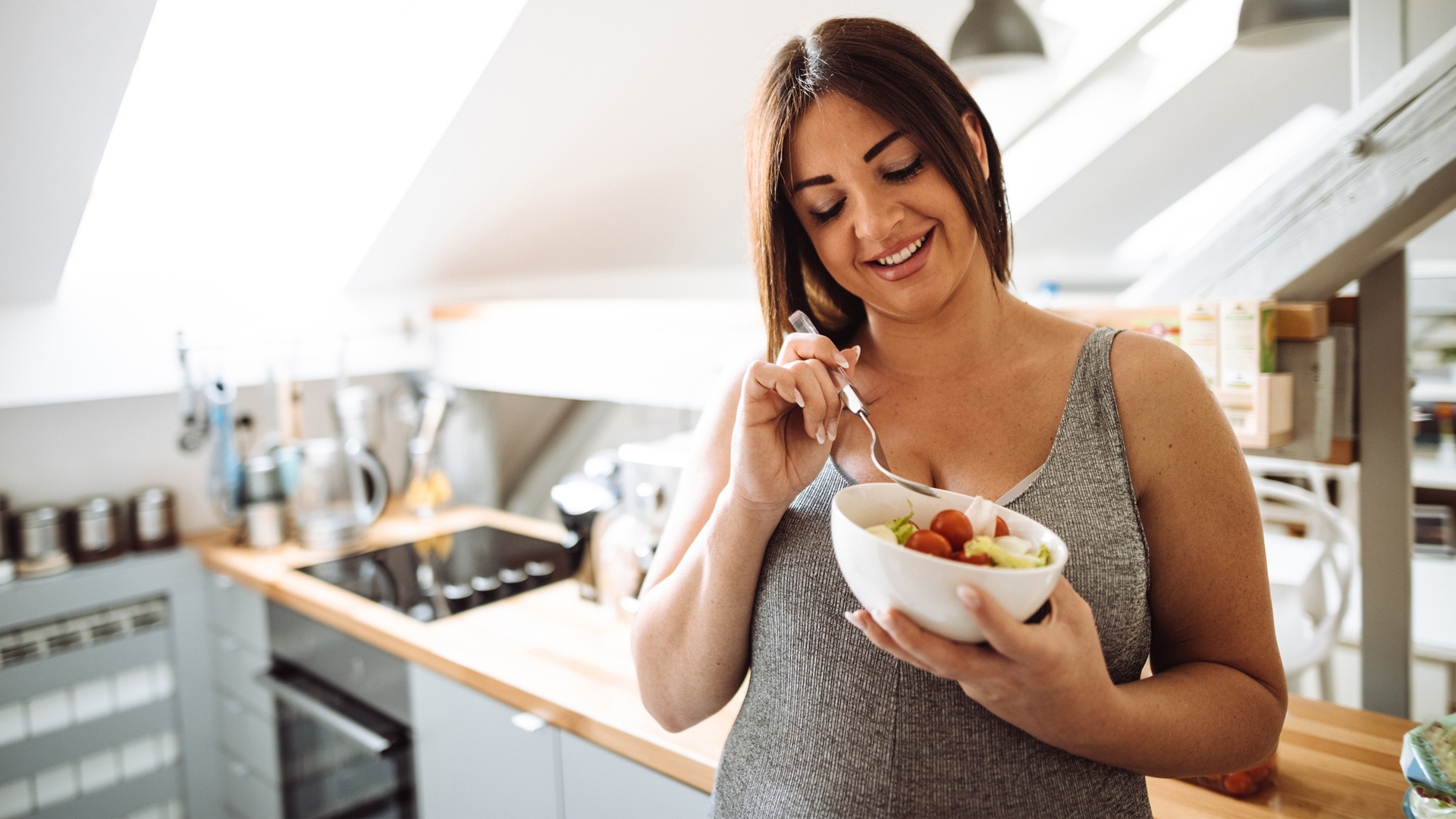 woman eating a bowl of oatmeal packed with prebiotics to support gut health