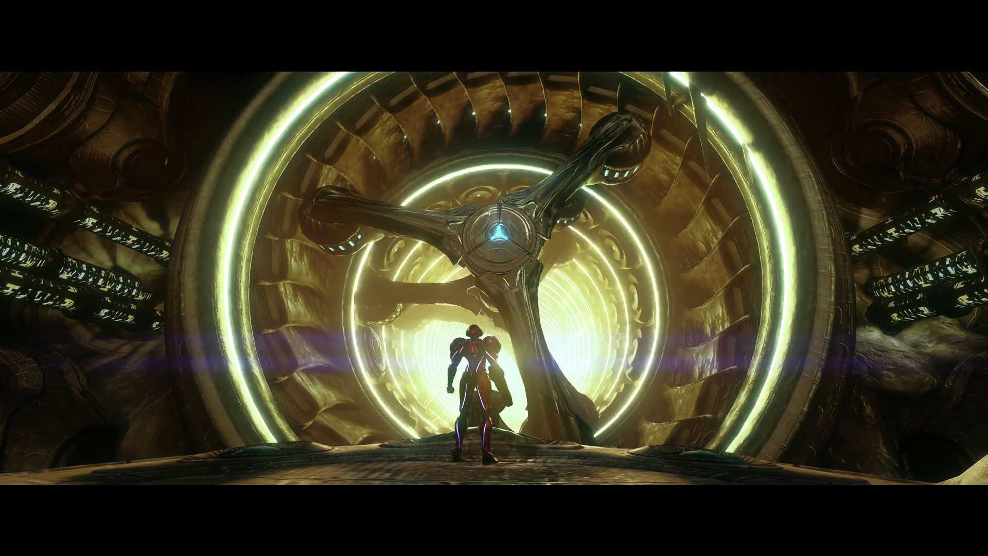 Samus stands in front of a huge, yellow, inactive generator in Metroid Prime 4: Beyond
