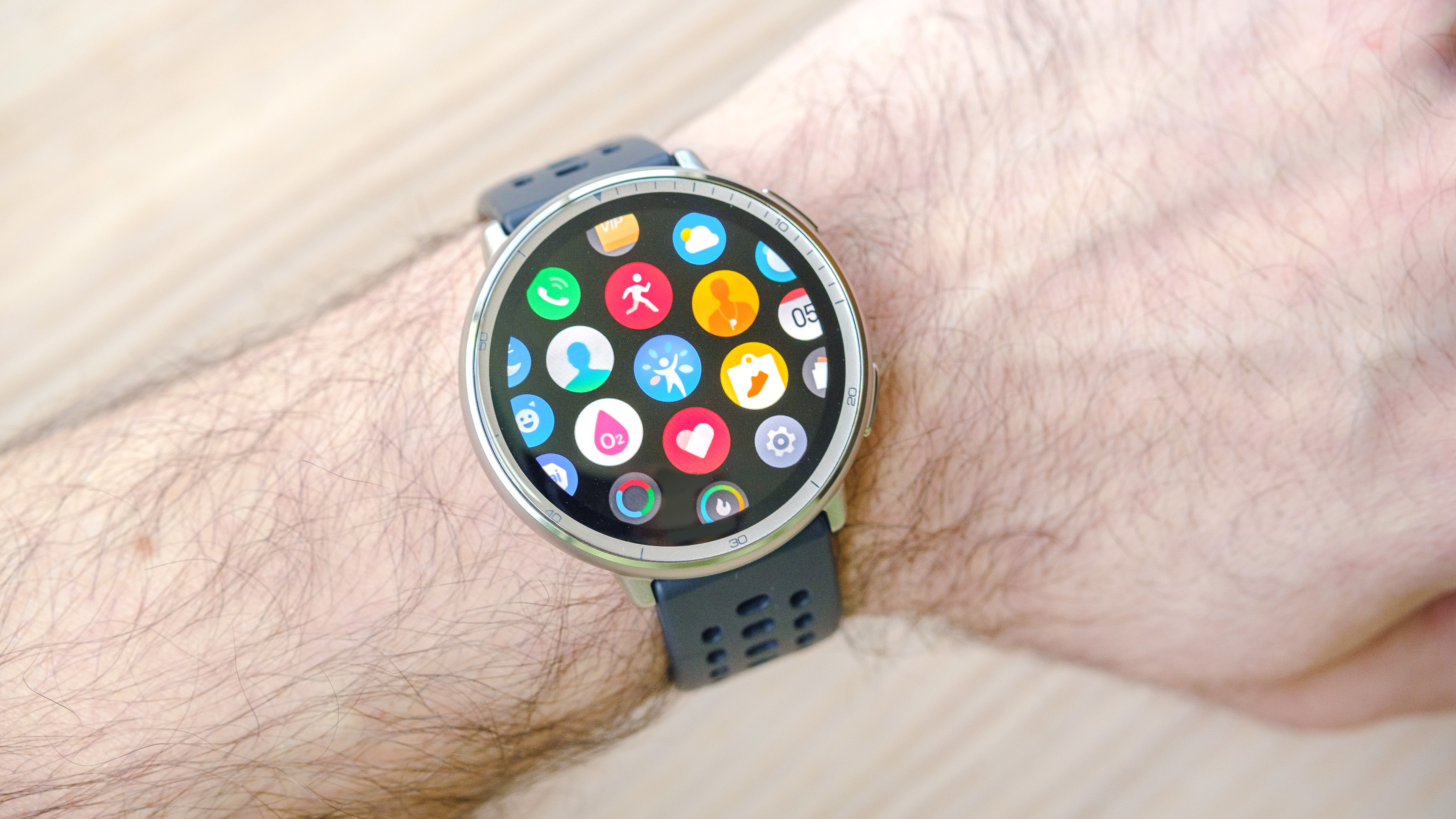 Close-up of the Amazfit Active 2 smartwatch on a user's wrist with the app library icons shown on the screen