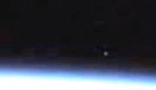 A bright spot appears in a video from the live camera on the International Space Station.