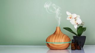 An electric diffuser with oils next to an orchid