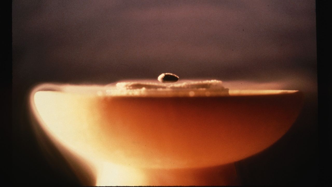 A piece of metal levitates over an electrical conductor, or superconductor