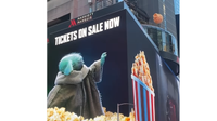 The Grogu billboard in Times Square showing Grogu using the force to bring popcorn closer. 