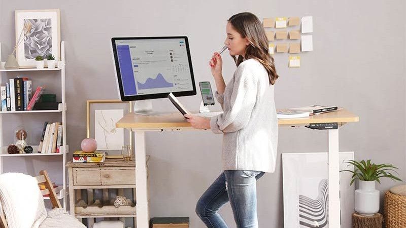 best standing desk: Woman using standing desk in home office