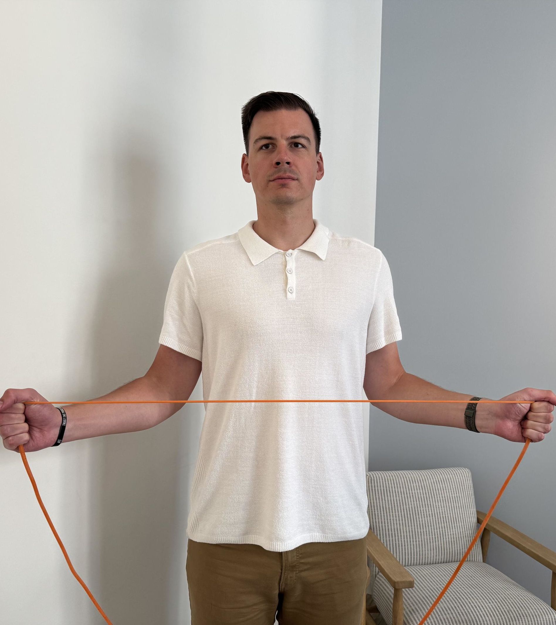 A man holding a thin orange resistance band